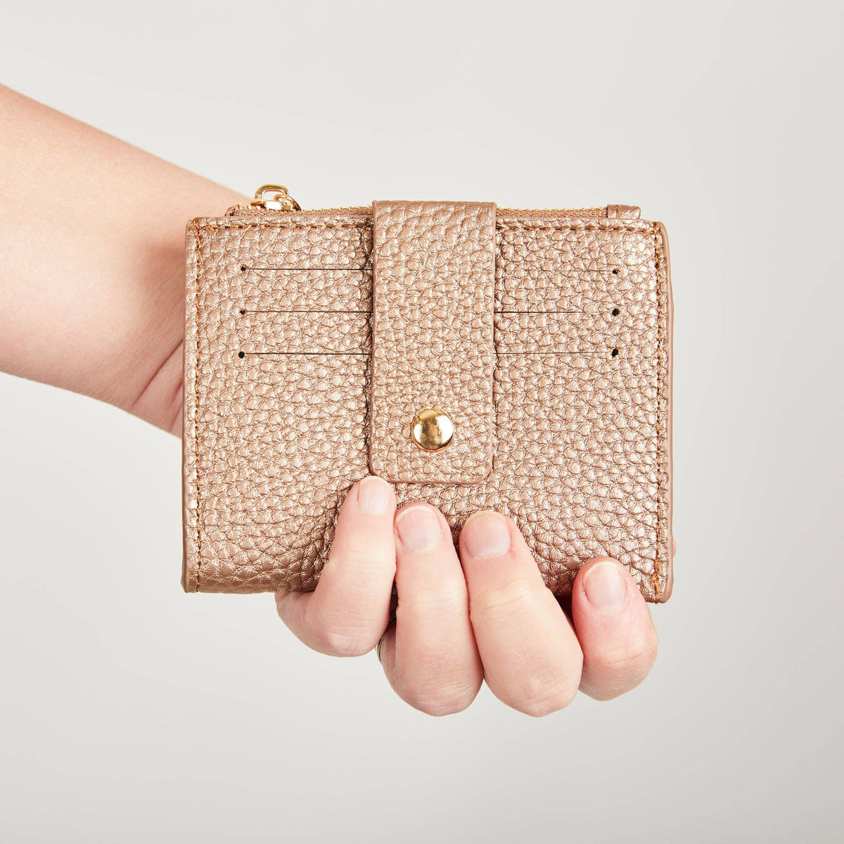 Rose gold Pearl Duo purse held in one hand to show its compact size.