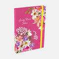 A pink sticky notes folder decorated with colorful floral illustrations and a yellow elastic closure band, shown on a light gray background.