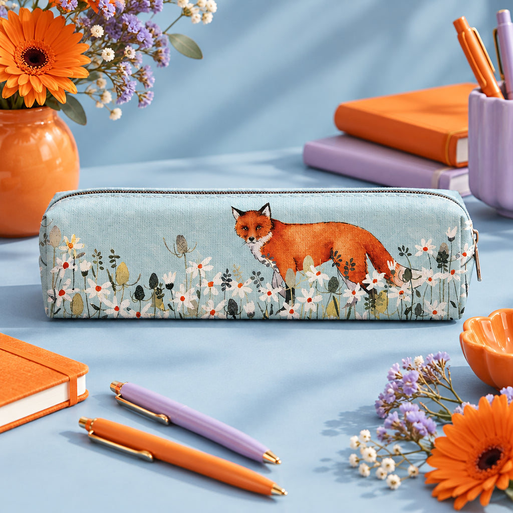  rectangular zippered pencil case featuring a printed design of an orange fox standing among white wildflowers on a pale blue background, shown against a light gray studio backdrop.