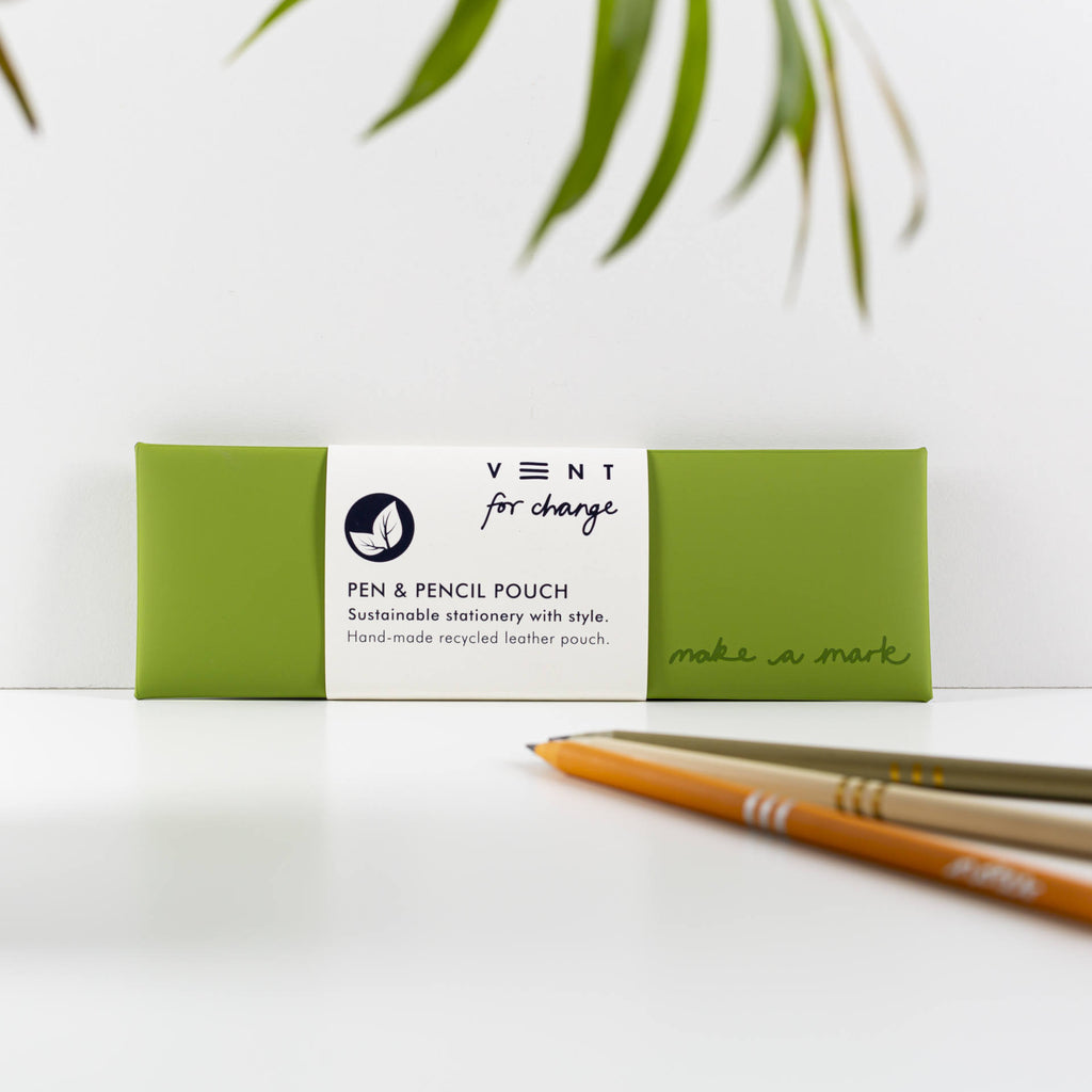 Green recycled leather pen and pencil case with a white paper sleeve, displayed beside pencils.