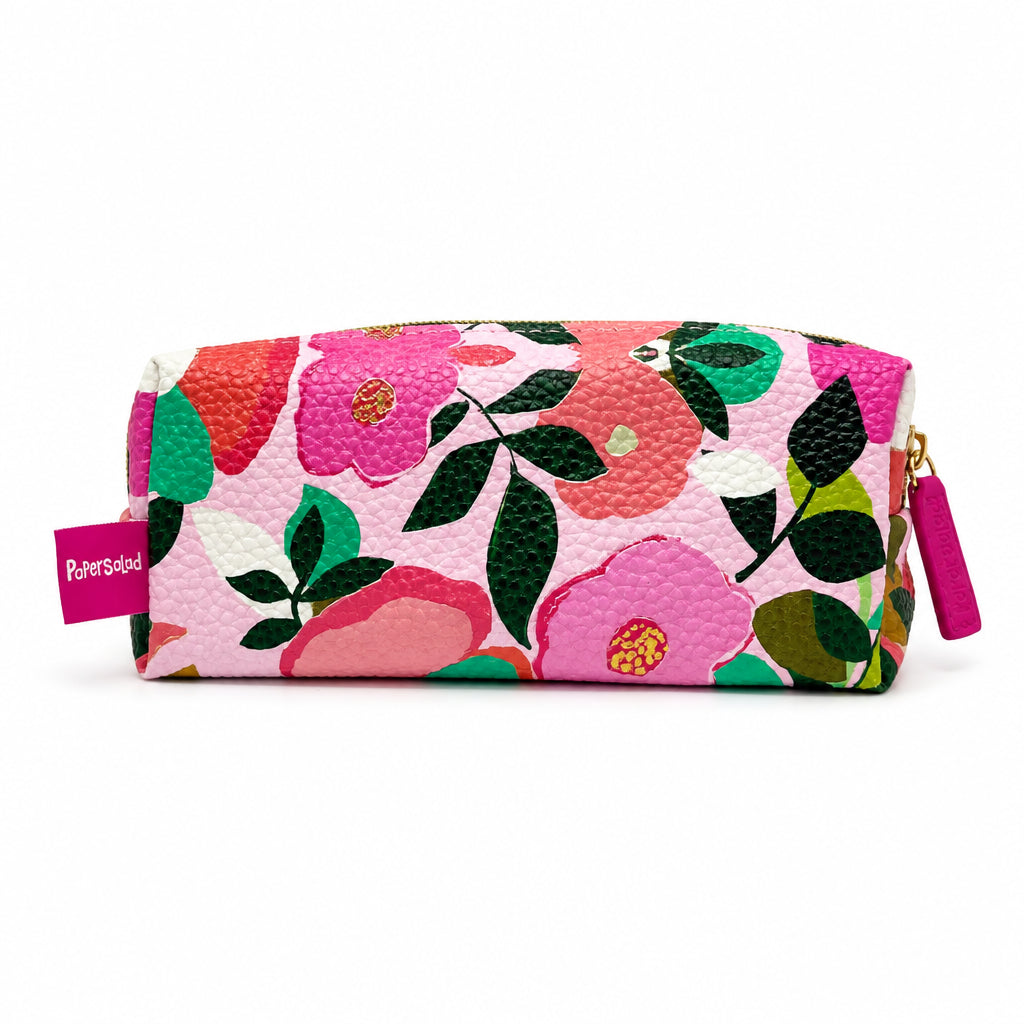 A rectangular zippered pouch with a textured pebbled finish, featuring a vibrant floral print in pink, orange, green, and white. A pink tag on the left reads 'Piper Sandler' and a matching pink zipper pull is visible on the right.
