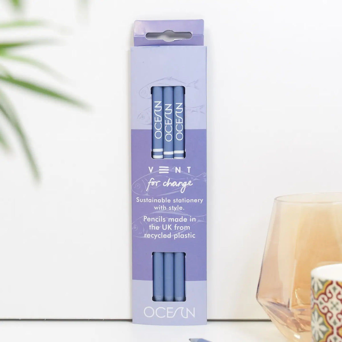  Three sea blue pencils in a blue presentation sleeve, displayed beside a plant and desk accessories
