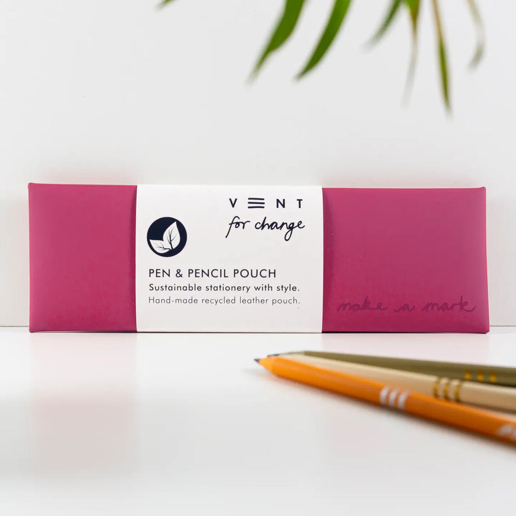 Raspberry Pink recycled leather pen and pencil case with a white paper sleeve, displayed beside pencils