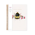 Spiral-bound notebook with a white cover featuring a watercolour bumblebee and pink flowers, with gold-toned spiral binding.