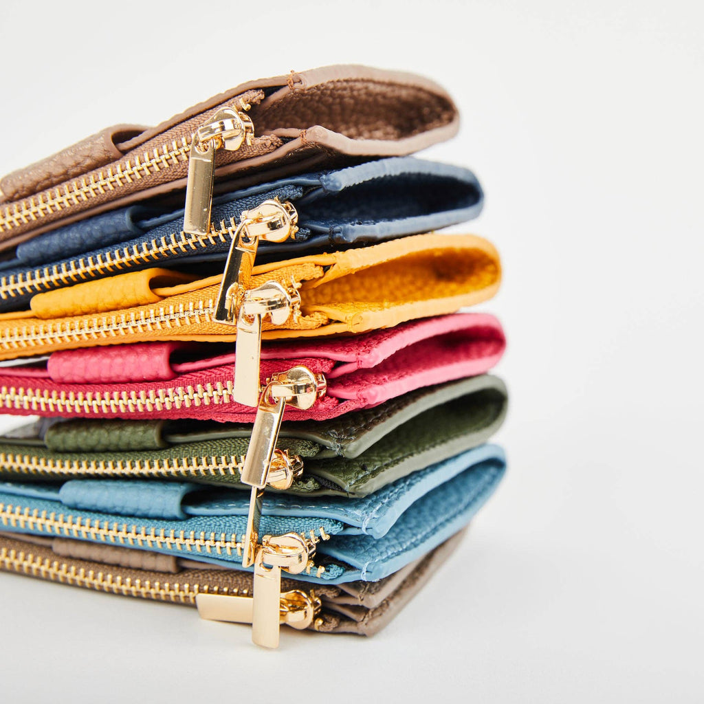 Close-up of stacked Pearl Duo purses in assorted colours, showing gold-tone zips and pulls