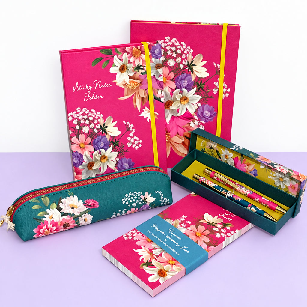 A stationery gift set featuring a floral notebook, a teal floral pencil case, a boxed set of pens, and a small floral notebook, all arranged on a white surface against a plain light background.