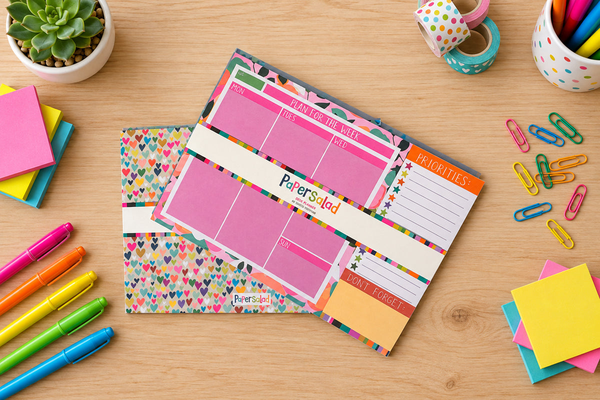 Colourful weekly planner displayed on a desk with colourful pens and other accessories.