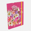 A hardcover notebook with a vibrant pink cover decorated with a colorful floral bouquet illustration, featuring a yellow elastic closure band, shown on a light gray background.