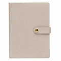 Nude A5 notebook with a textured cover and matching snap-button strap closure, on a white background.