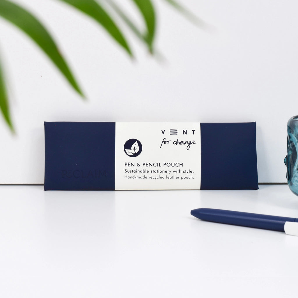 Navy Blue recycled leather pen and pencil case with a white paper sleeve, displayed beside a navy pen