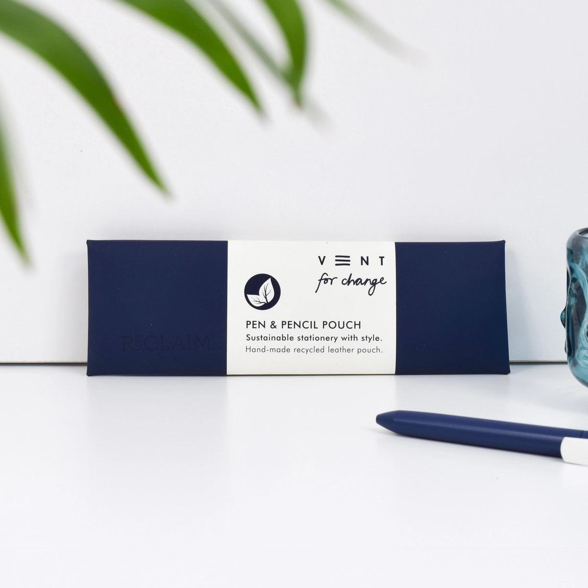 Navy Blue recycled leather pen and pencil case with a white paper sleeve, displayed beside a navy pen
